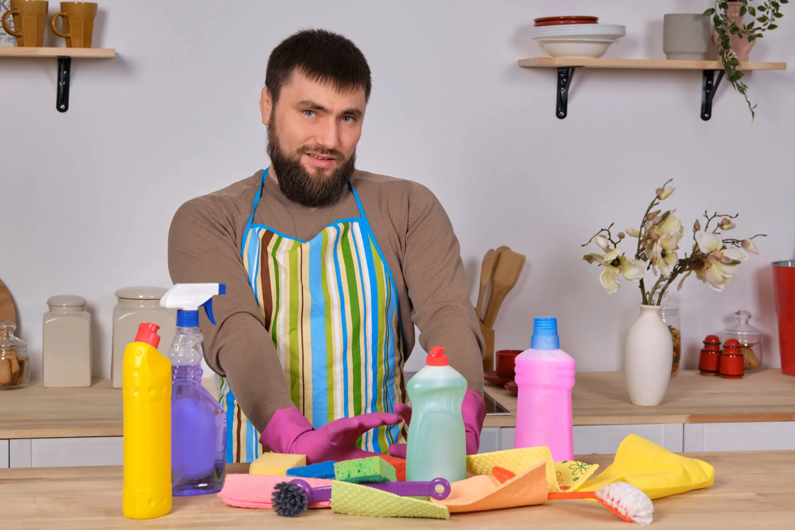 KSA Household Cleaners Market Outlook to 2035 young-handsome-bearded-man-kitchen-shows-all-his-cleaning-staff-detergents-brushes-sprays-he-think-he-is-ready-real-cleaning-scaled