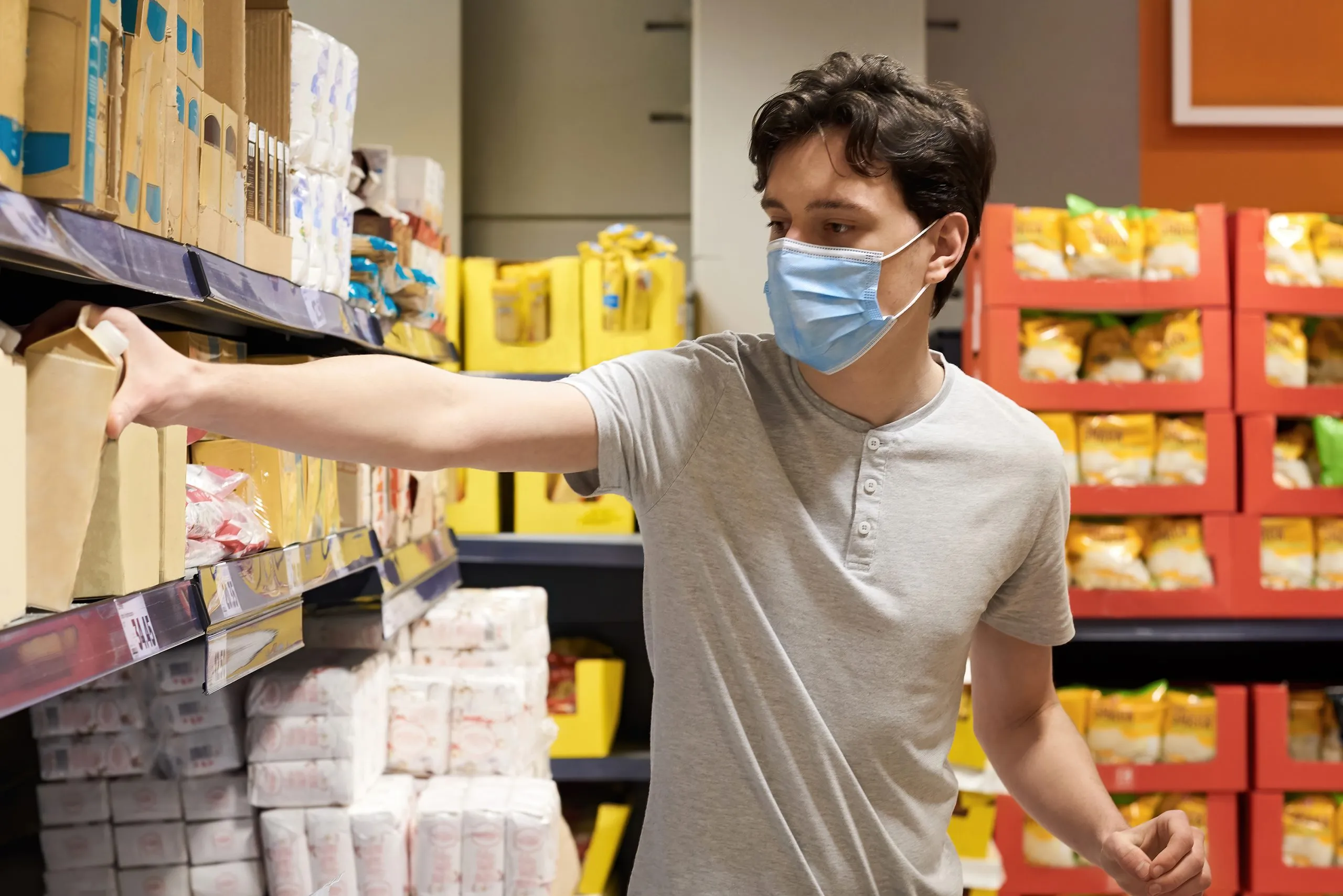 Singapore Adult Diaper Market Outlook to 2035 young-man-with-face-mask-looking-snacks-supermarket-scaled