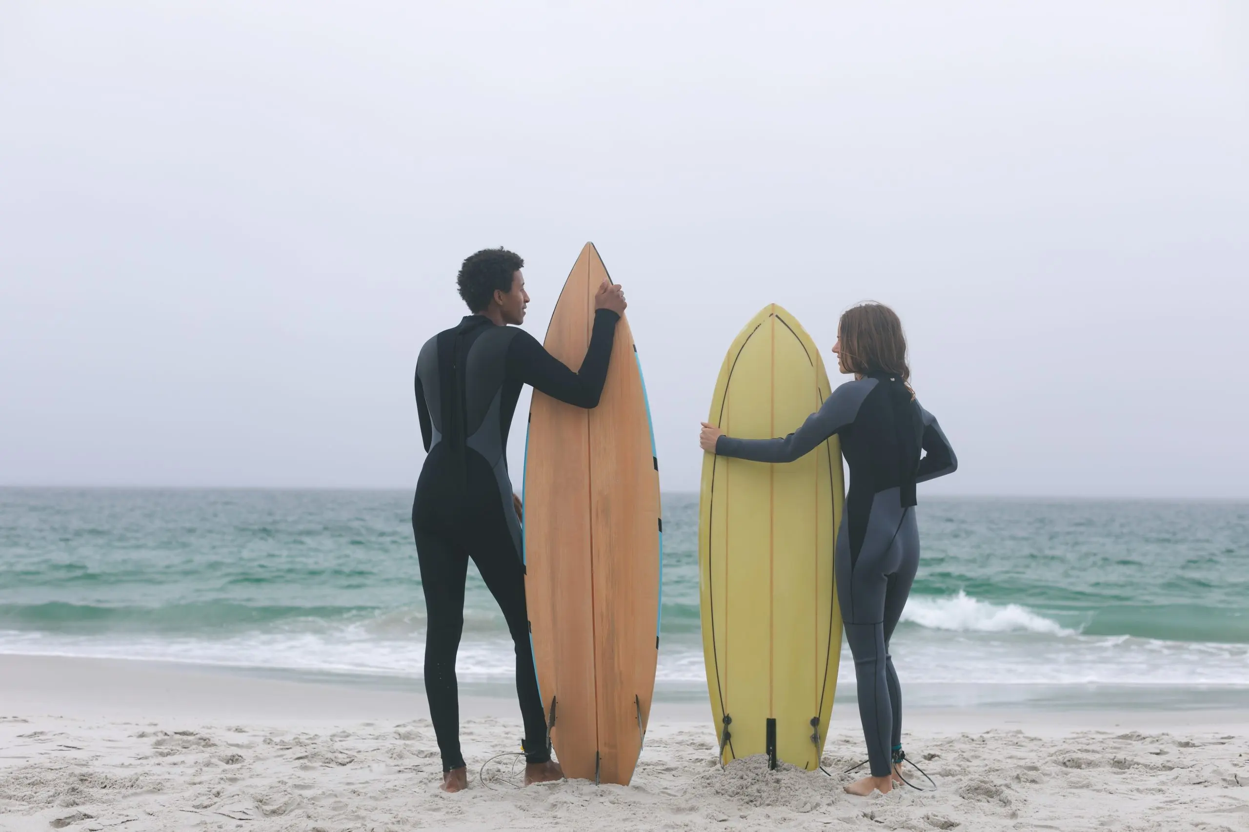 UK Surfing Equipment Market Opportunities Rise as Global Revenue Heads Toward US$6.9 Billion couple-surfer-holding-surfboard-beach-scaled