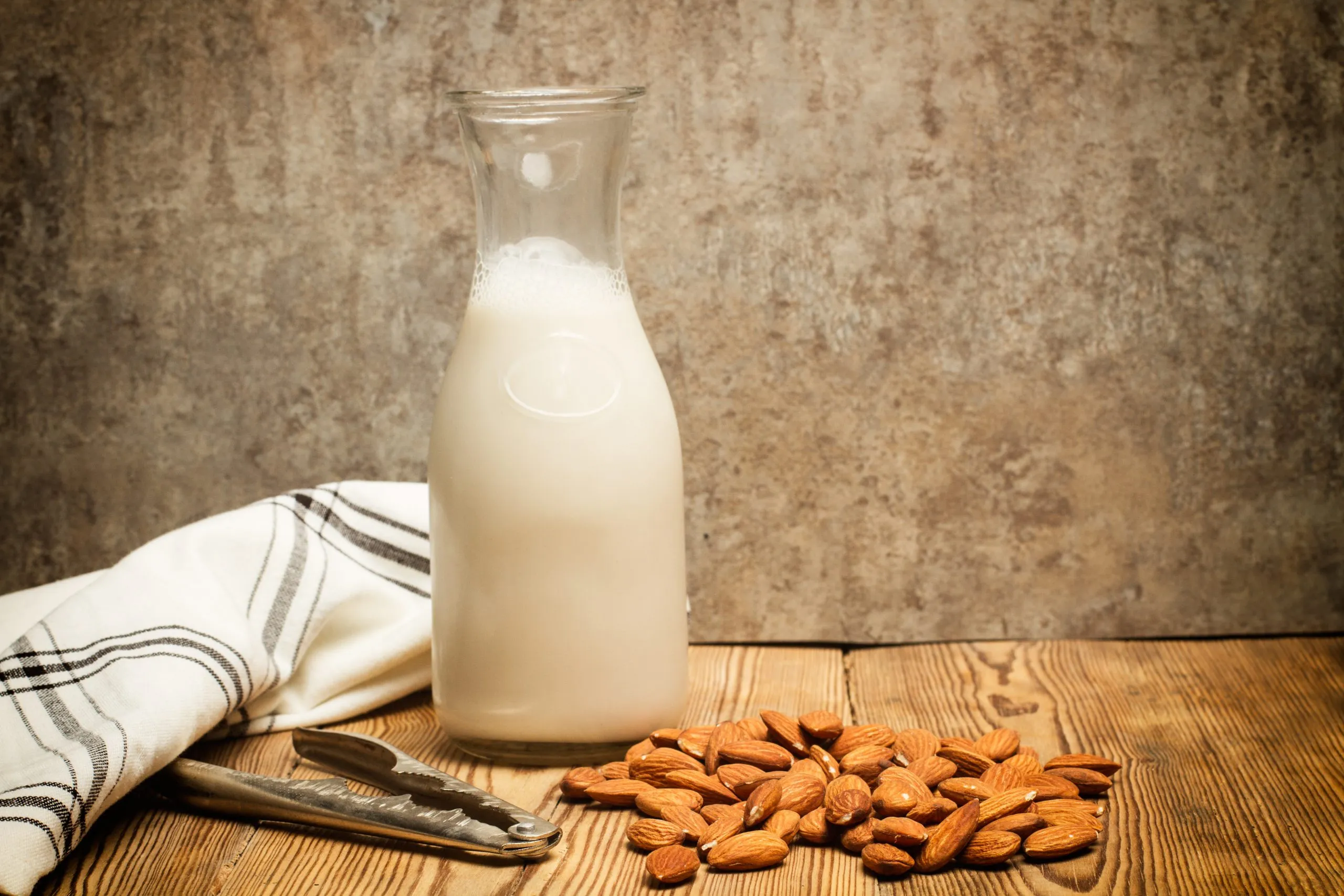 UK Almond Milk Market Expected to Surpass USD 1.4 Billion Driven by Growing Vegan Consumer Demand bottle-milk-almonds-wooden-table-scaled