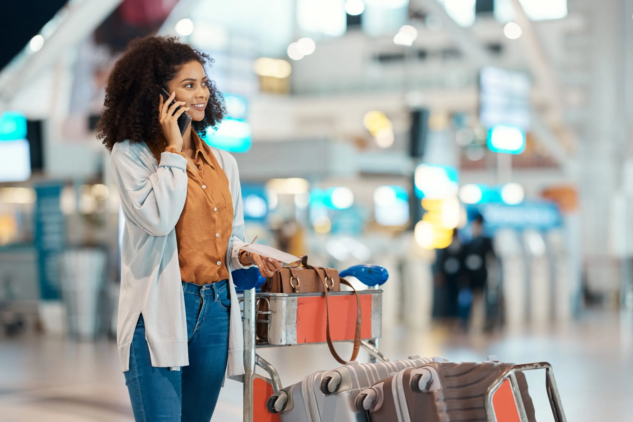Nigeria Duty Free And Travel Retail Market Strengthens as Global Duty Free And Travel Retail Grows at 6.50 Percent CAGR phone-call-travel-happy-black-woman-airport-with-trolley-luggage-suitcase-global-trip-vacation-communication-girl-smartphone-schedule-talking-flight-details-scaled