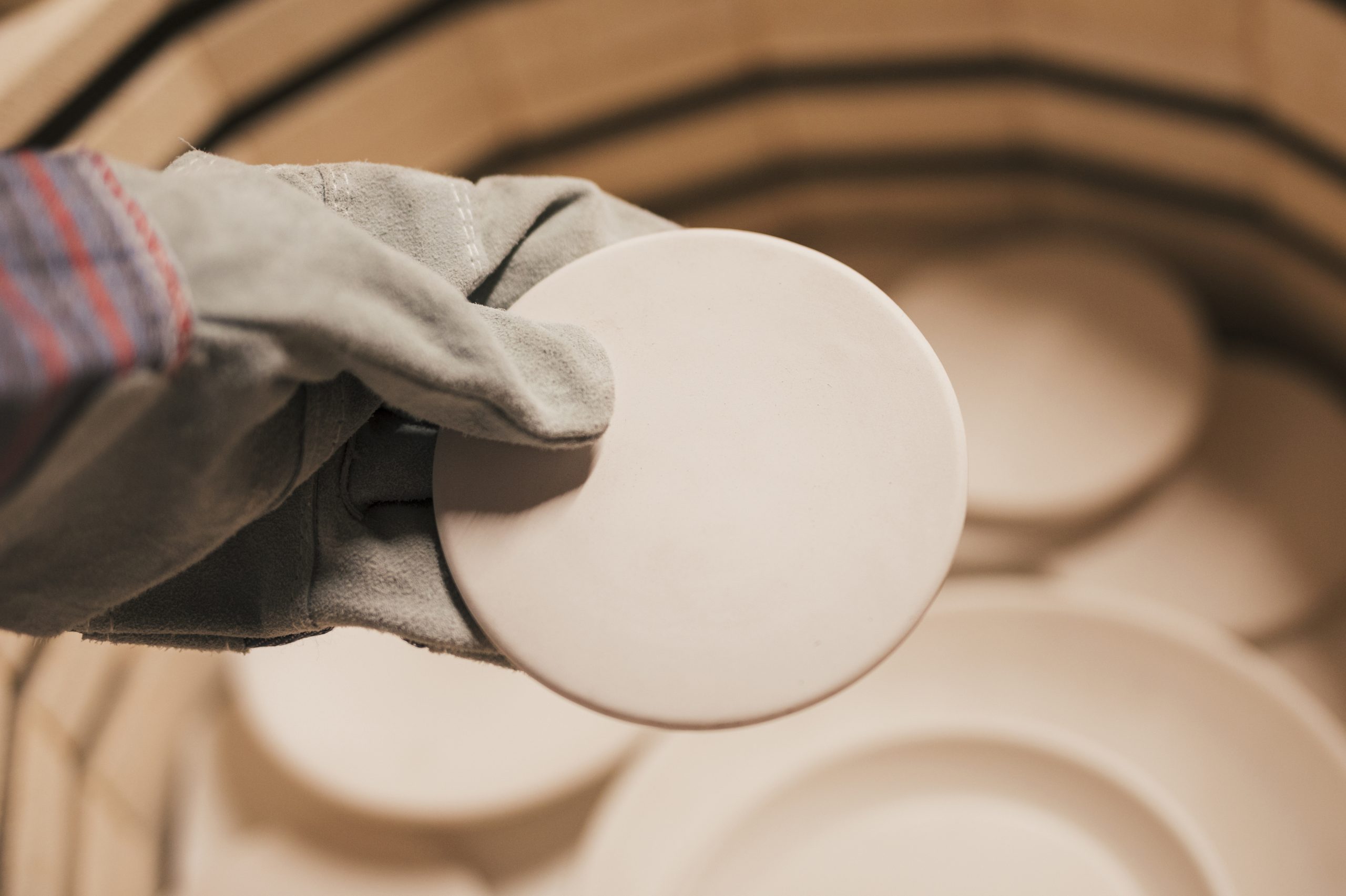US Advanced Ceramics Market Advances with USD 35.2 Billion Value and Emerging Technology Applications close-up-female-s-hand-wearing-gloves-holding-ceramic-plates-1-scaled