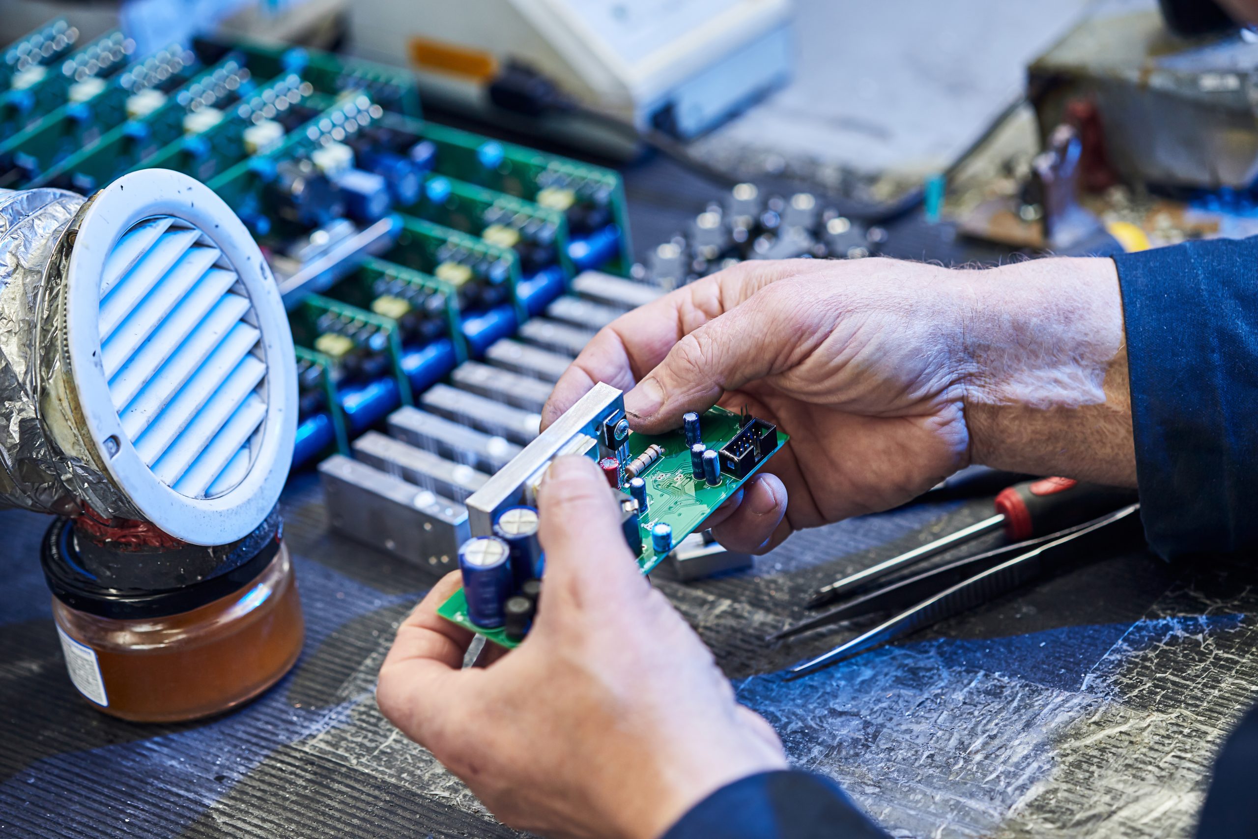 KSA Flexible Electronics and Circuit Market Outlook to 2035 repairing-hardware-equipment-repair-shop-worker-with-tools-microchip-circuit-board-testing-modern-digital-device-desk-electronic-devices-concept-scaled