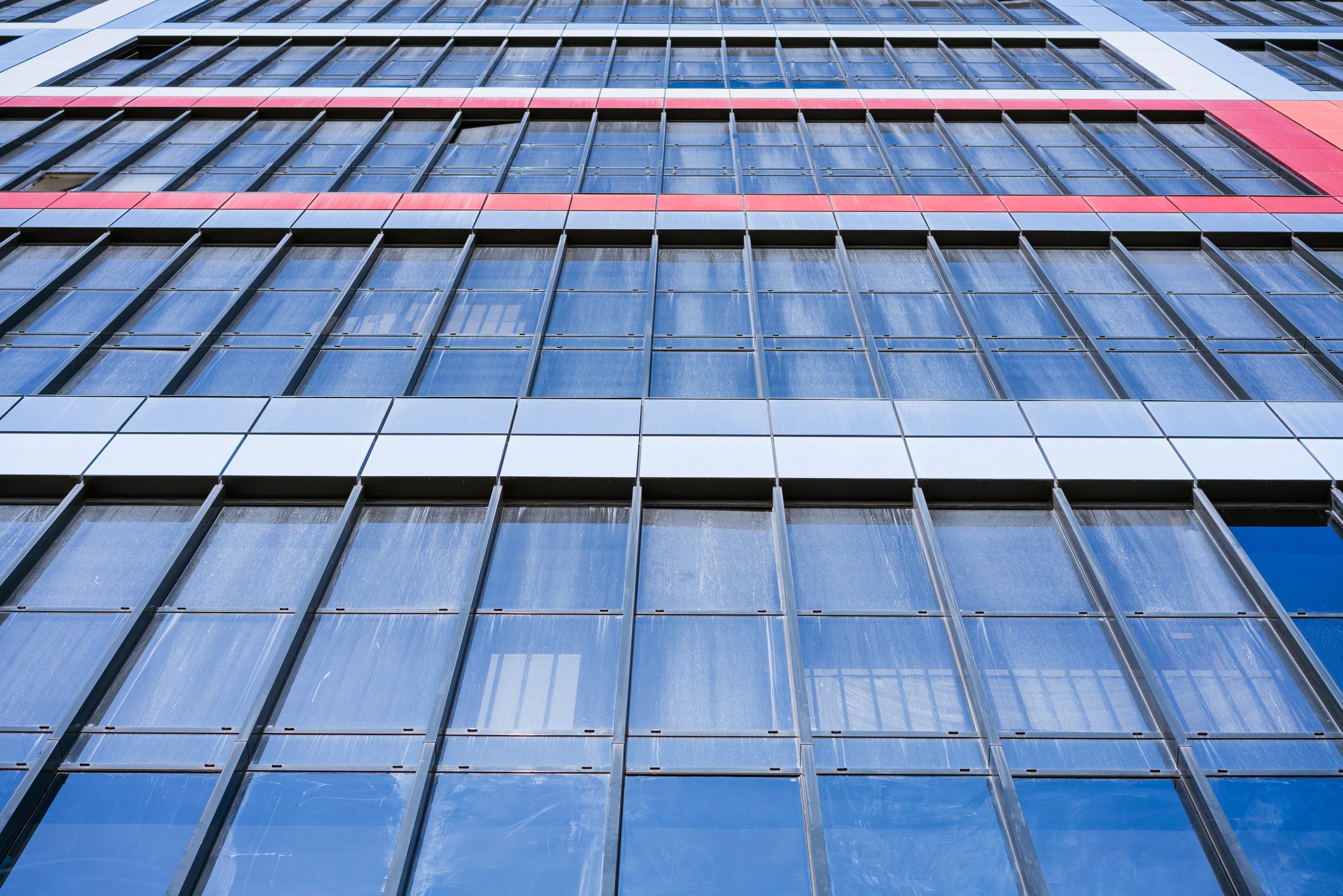glass-facade-house-against-blue-sky-bottom-view-scaled