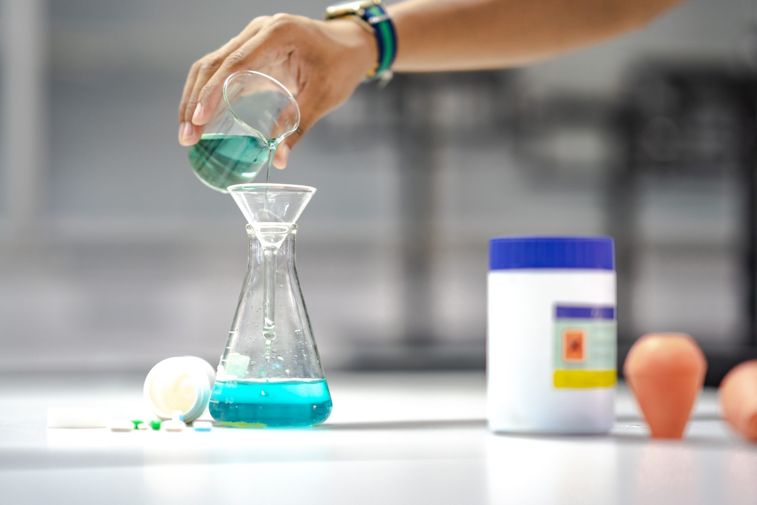 Malaysia Repair and Rehabilitation Chemicals Market Outlook to 2035 hand-holding-chemical-beaker-pouring-flask-test-reaction-drug-medicine-scaled