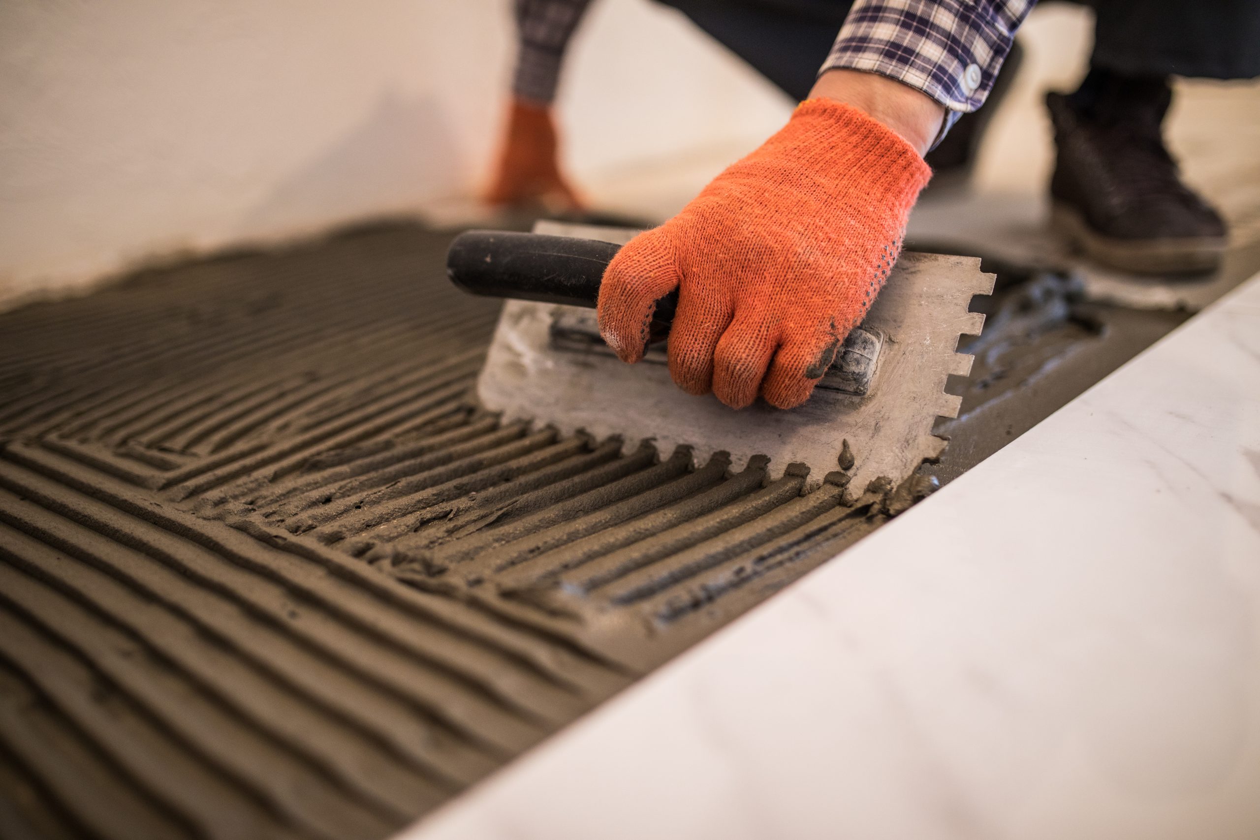 US Tile Adhesives Market Outlook to 2035 laying-ceramic-tiles-troweling-mortar-onto-concrete-floor-preparation-laying-white-floor-tile-scaled